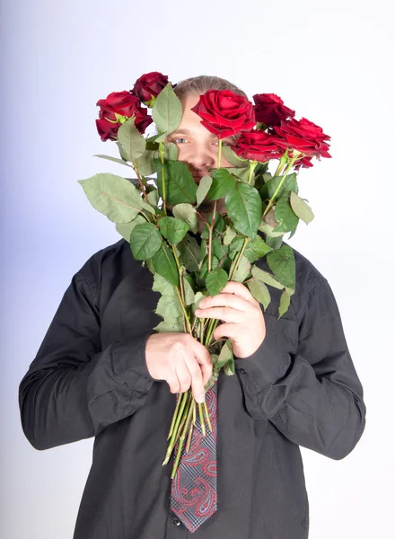 Handsome man offering you a bunch of red roses — Stock Photo, Image