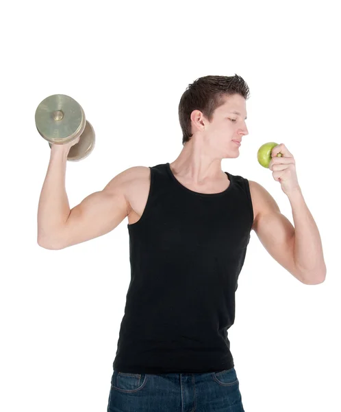 Knappe gespierde man eet een appel terwijl het doen van de biceps krullen — Stockfoto