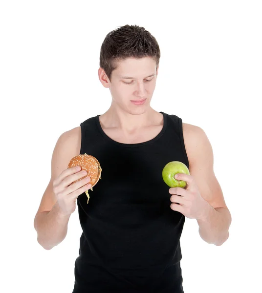 Porträt eines Mannes, der sich zwischen Hamburger und grünem Apfel entscheidet — Stockfoto