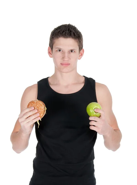 Portrait of man choosing between hamburger and green apple — Stock Photo, Image