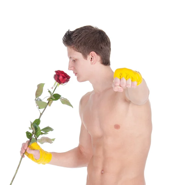 Uomo sano che indossa impacchi di formazione che tengono una rosa su uno sfondo bianco — Foto Stock