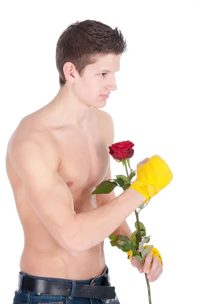 Здоровий чоловік в тренувальних обгортаннях тримає троянду на білому тлі — стокове фото