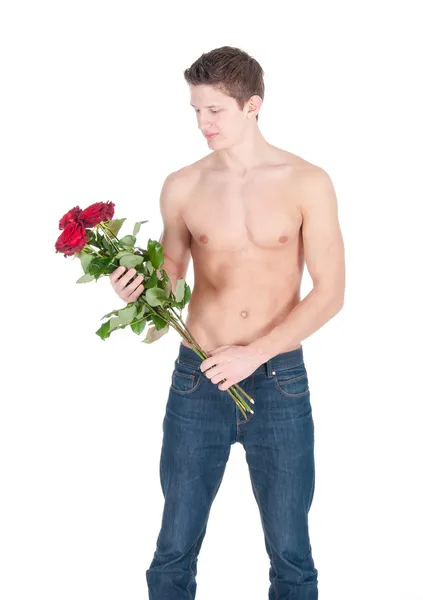 Jovem sexy com tronco nu e cacho de rosas vermelhas em um fundo branco — Fotografia de Stock