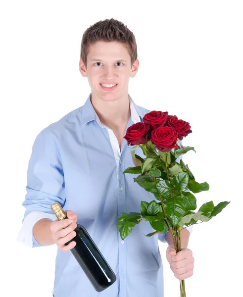 Homme souriant portant une chemise bleue avec un bouquet de roses rouges et une bouteille de vin — Photo