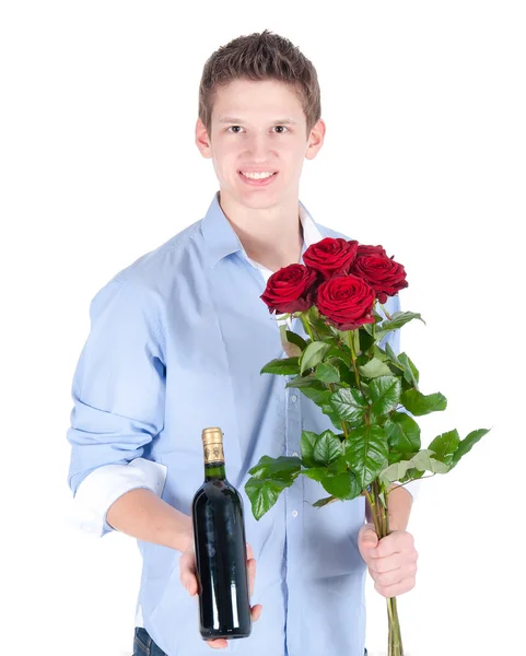 Homme souriant portant une chemise bleue avec un bouquet de roses rouges et une bouteille de vin — Photo