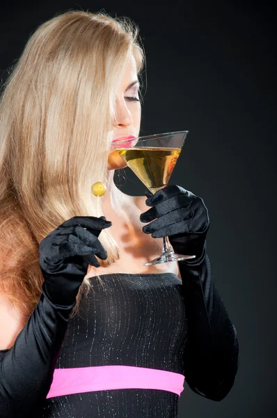 性感的金发碧眼女人杯马提尼酒和橄榄油在黑暗的背景 — 图库照片