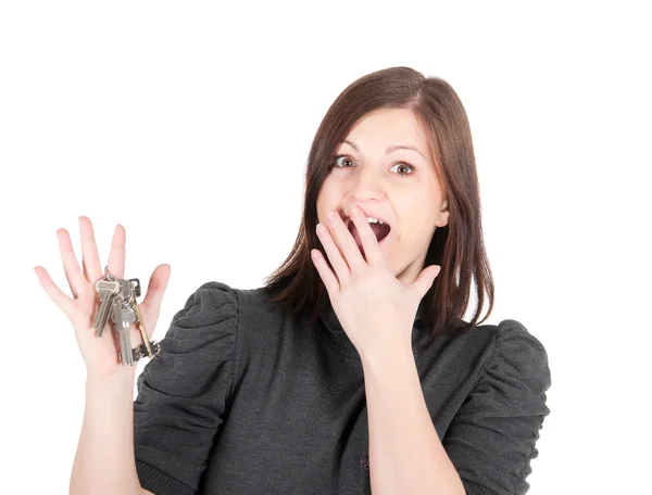 Jovem bela mulher mostrando as chaves do apartamento no fundo branco — Fotografia de Stock