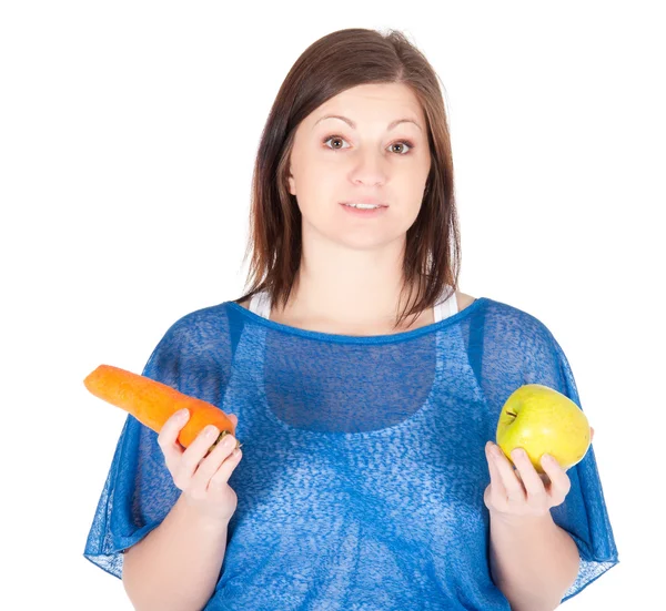 Young woman chose between apple and carrot over white background — Stock Photo, Image