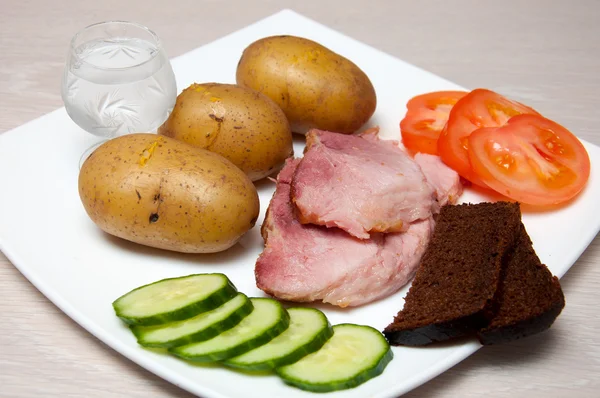 Grillad fläskfilé med vodka, boled potatis, grönsaker och bröd — Stockfoto