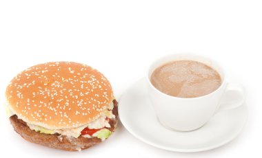 bir büyük hamburger ve kahve fincan beyaz zemin üzerine yakın çekim.