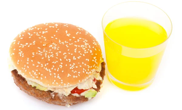 Close up of a real Big hamburger and glass of orange juice on white background. — Stock Photo, Image