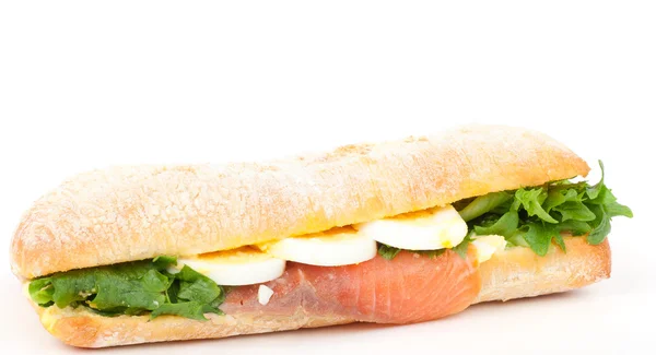 Real sandwich with smoked salmon, eggs and green on a white background. — Stock Photo, Image