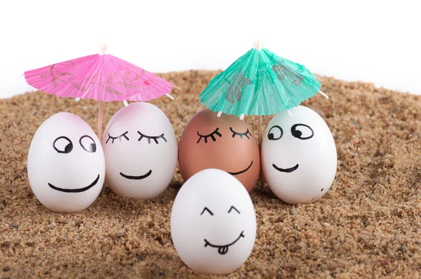 Easter funny eggs under umbrella on a sand — Stock Photo, Image