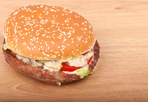 Real big tasty hamburger on a wooden background — Stock Photo, Image