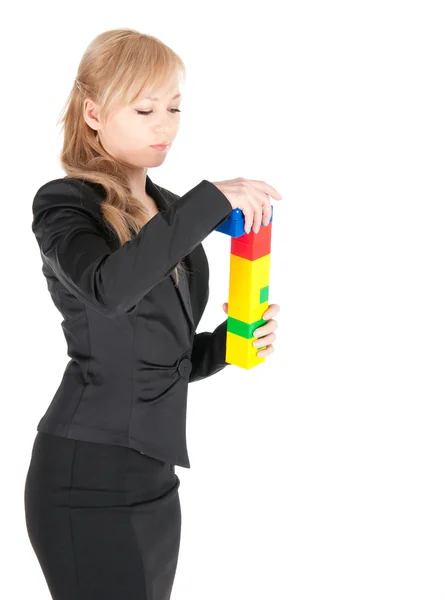 Young beautiful business woman with plastic blocks posing on white background — Stock Photo, Image