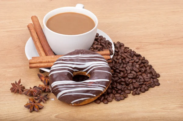 Coffee cup with coffee beans ans sweet cake on a wooden background — Stock Photo, Image