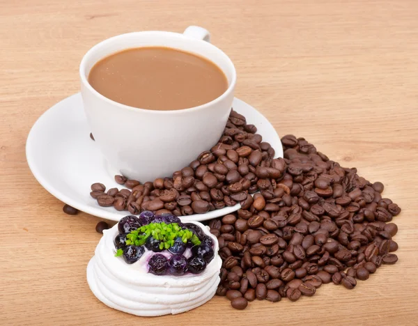Кофейная чашка с кофейными зернами сладкий торт на деревянном фоне — стоковое фото