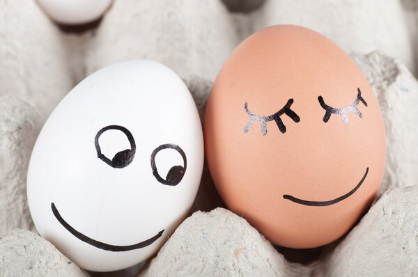 два смешных улыбающихся яйца в упаковке

