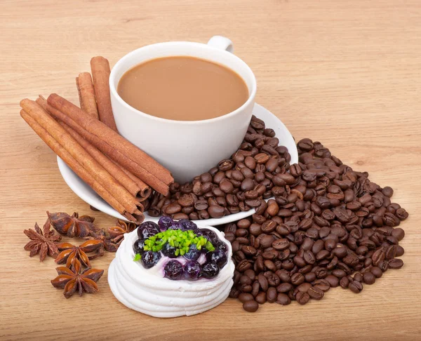 Coffee cup with coffee beans ans sweet cake on a wooden background — Stock Photo, Image