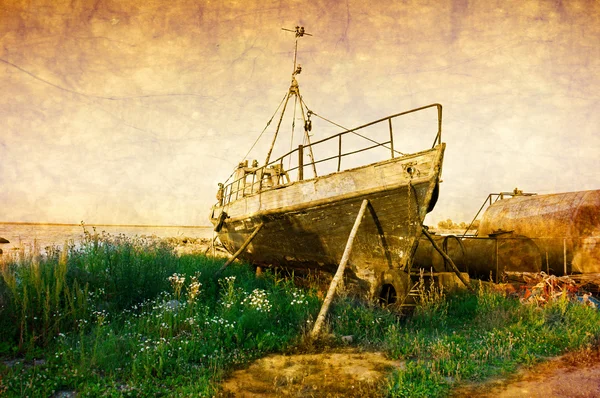 Old rusty boat at seashore with green grass