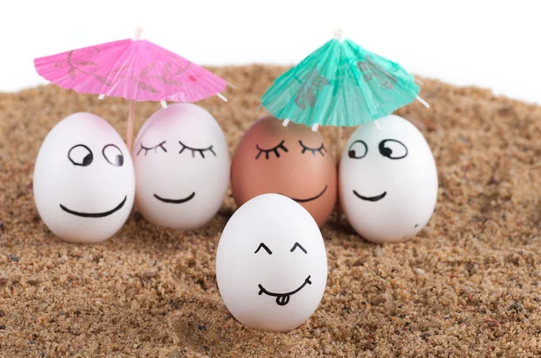 Ovos engraçados de Páscoa abaixo do guarda-chuva em uma areia — Fotografia de Stock