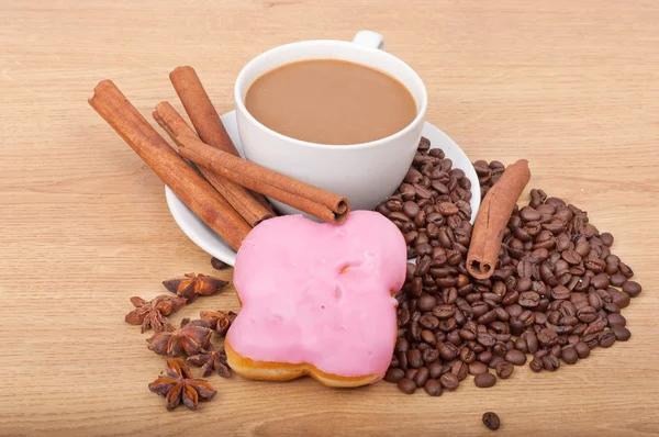 Coffee cup with coffee beans ans sweet cake on a wooden background — Stock Photo, Image