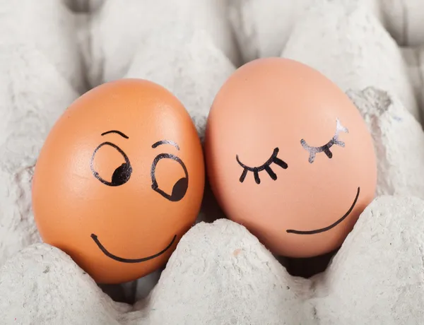 Два смешных улыбающихся яйца в упаковке — стоковое фото