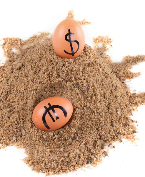 Image of big white eggs with dollarand euro signs on a sand — Stock Photo, Image