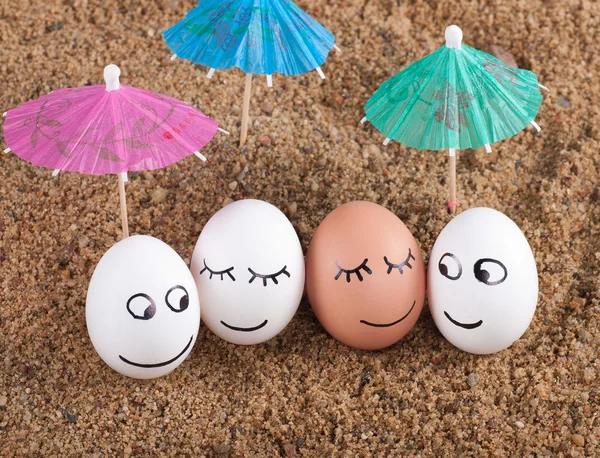 Pâques oeufs drôles sous parapluie sur un sable — Photo