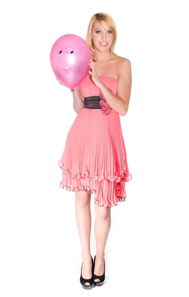 Žena v růžových šatech s úsměvem vzduchu míč — Stock fotografie