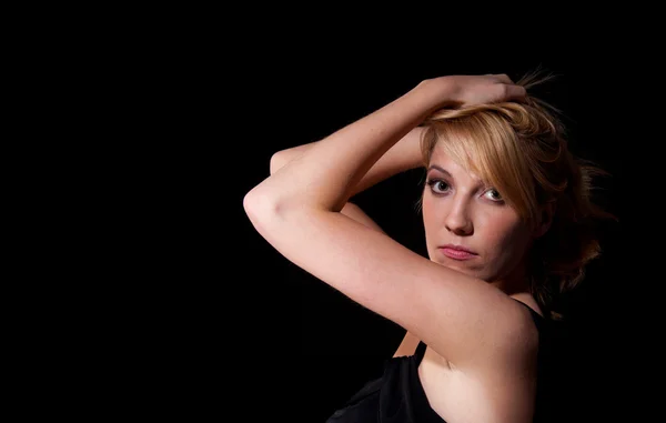 Frau in schwarzem Kleid vor dunklem Hintergrund — Stockfoto