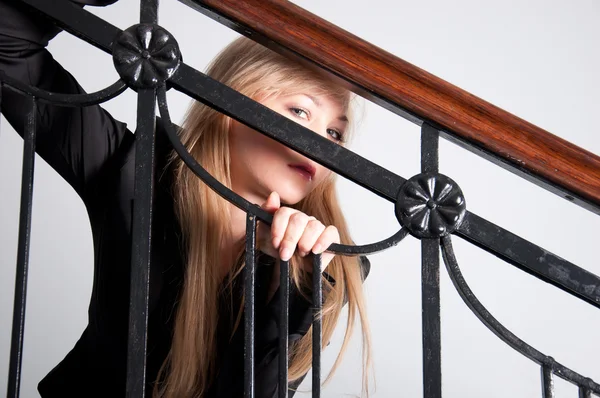 Sexy woman wearing blue jeans sitting on a stairs — Stock Photo, Image