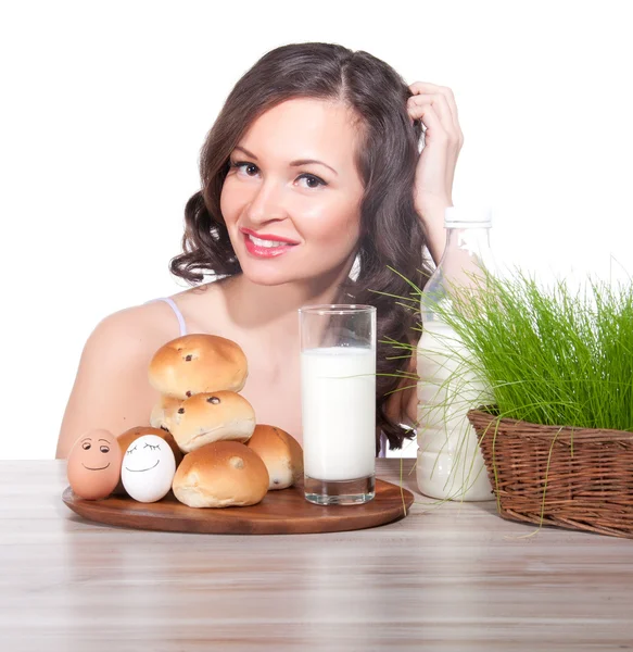 Bela mulher com leite, pão e cesta de Páscoa de grama — Fotografia de Stock