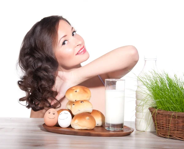 Gyönyörű nő fű tej, a zsemle és a húsvéti kosárral — Stock Fotó
