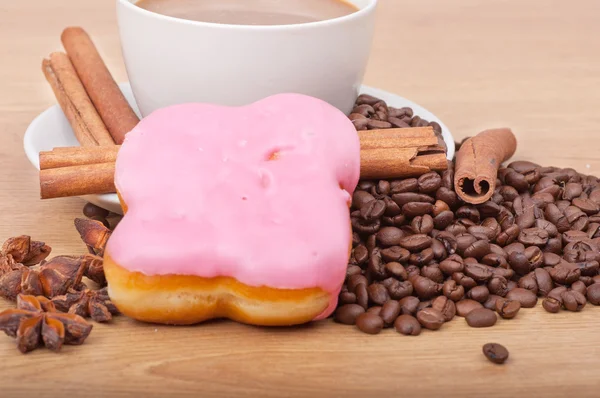 Koffiekopje met koffiebonen ans zoete cake op een houten achtergrond — Stockfoto