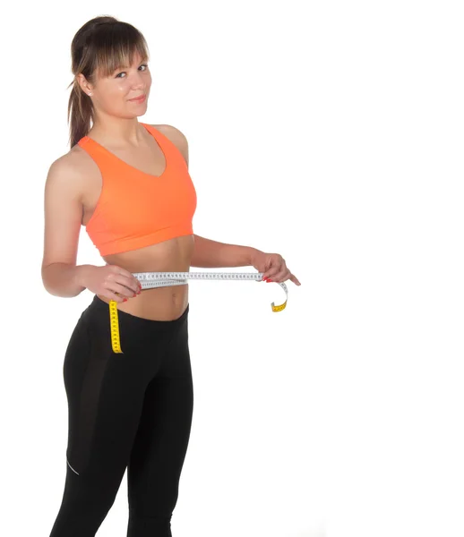 Beautiful slim woman measuring her waistline with a measuring tape — Stock Photo, Image