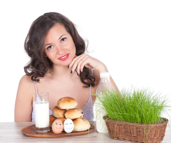 Hermosa mujer con leche, bollo y canasta de pascua de hierba — Foto de Stock