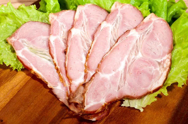 Ham and lettuce on a wooden plate — Stock Photo, Image