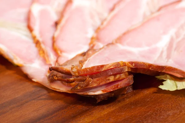 Macro shot of ham and lettuce on a wooden plate — Stock Photo, Image