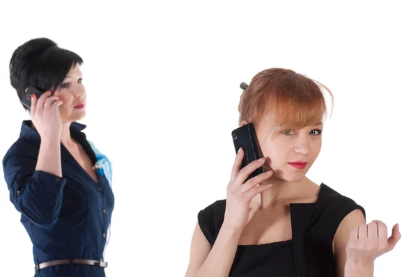 Дві жінки розмовляють по мобільних телефонах і посміхаються — стокове фото