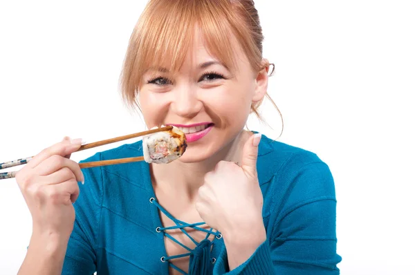 Beautiful young woman eating sushi with chopsticks — Stock Photo, Image