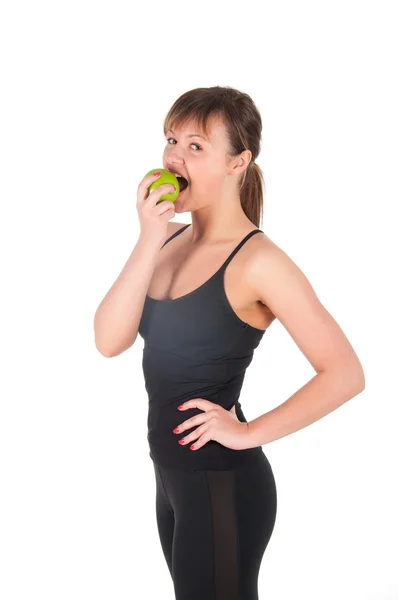 Schöne junge Sportlerin mit grünem Apfel, isoliert auf weiß — Stockfoto