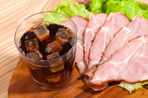 Ham and lettuce with glass of a cola on a wooden plate — Stock Photo, Image