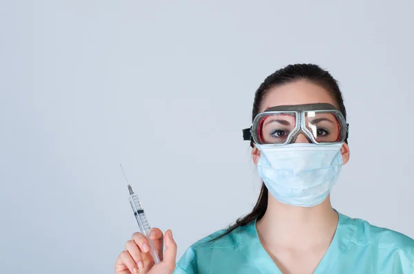 Nurse or doctor in pilot glasses with syringe and mask — Stock Photo, Image