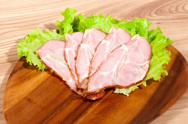 Ham and lettuce on a wooden plate — Stock Photo, Image