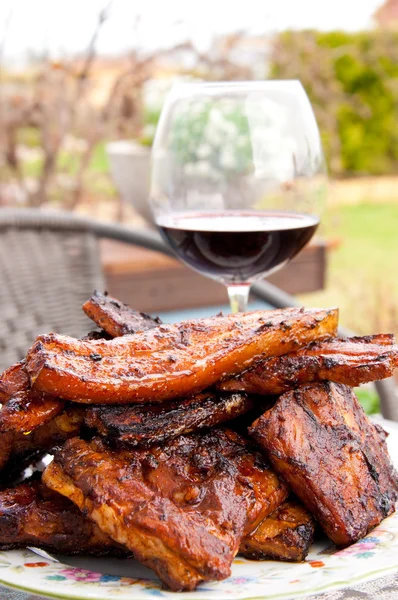 grill meat on a plate with glass of wine.