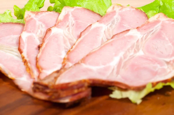 Macro shot of ham and lettuce on a wooden plate — Stock Photo, Image