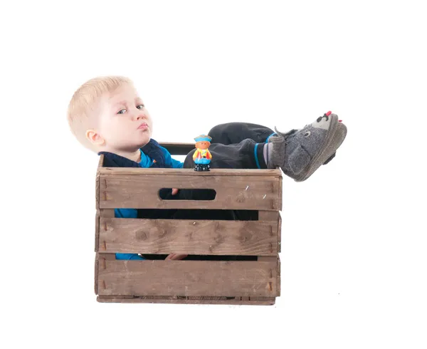 Little boy in wooden box — Stock Photo, Image