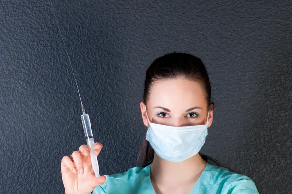 Nurse or doctor with syringe and mask — Stock Photo, Image