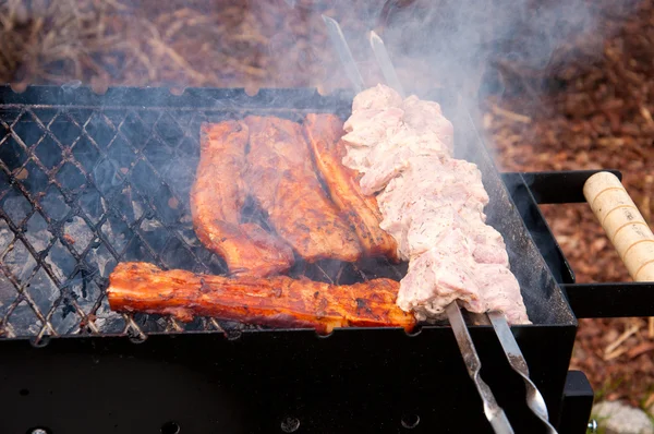 Bbq ribs and bacon on a grill with charcoal — Stock Photo, Image